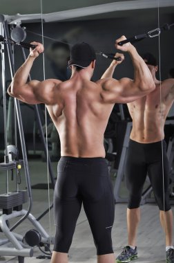 Kabloları ile pazı egzersiz yapan yakışıklı güçlü atletik erkek. Mükemmel kaslı güçlü vücut geliştirmeci.