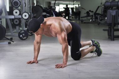 Push up salonunda gerçekleştirmek için hazırlanıyor yakışıklı güçlü atletik bir adam. Mükemmel sırt, omuz, pazı, triceps ve göğüs ile güçlü vücut geliştirmeci.