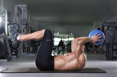 ABS egzersiz sağlık topu ile gerçekleştirme yakışıklı güçlü atletik bir adam. Mükemmel abs ve kolları ile güçlü vücut geliştirmeci.