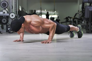 Push up salonunda gerçekleştirme yakışıklı güçlü atletik bir adam. Mükemmel sırt, omuz, pazı, triceps ve göğüs ile güçlü vücut geliştirmeci.