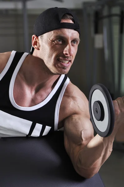 Pěkný silný atletický muž dělá činka biceps cvičení. Silné kulturista s dokonalou svaly. — Stock fotografie