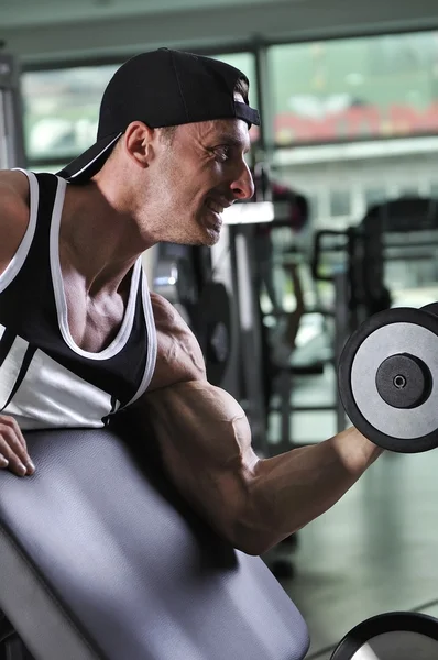 Knappe krachtige atletische man je biceps-oefening met dumbbell doet. Sterke bodybuilder met perfecte spieren. — Stockfoto