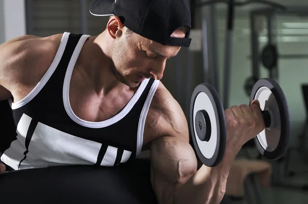 Hombre atlético poderoso guapo haciendo ejercicio bíceps con mancuerna. Culturista fuerte con músculos perfectos . —  Fotos de Stock