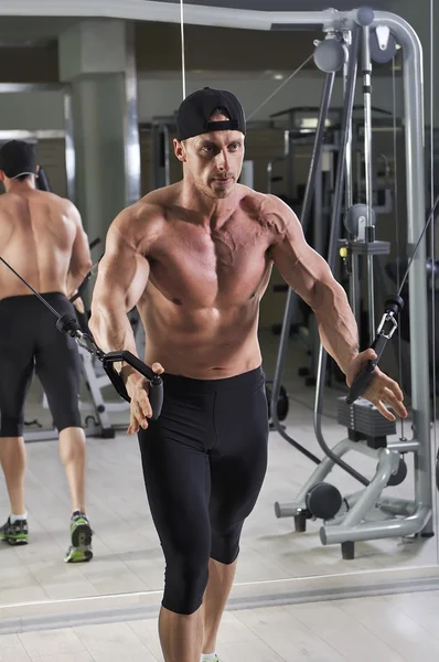 Bonito homem atlético poderoso fazendo cabo crossover exercício. Forte fisiculturista com abdominais perfeitos, peito e braços . — Fotografia de Stock