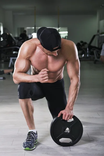 Bonito homem atlético poderoso se preparando para o exercício com peso. Forte fisiculturista com perfeito, ombros, braços e peito . — Fotografia de Stock