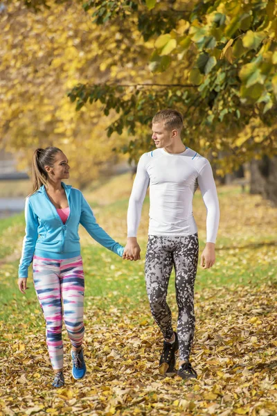 Hermosa pareja joven caminando juntos en el parque. Ambiente otoñal . —  Fotos de Stock