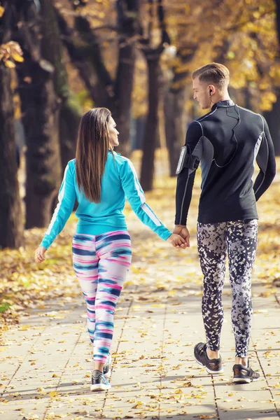 Vackra unga par promenader tillsammans i parken. Höstens miljö. — Stockfoto