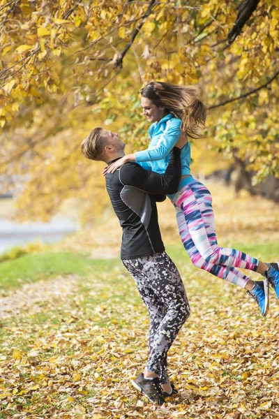 Vackra unga par njuter tillsammans i parken. Höstens miljö. — Stockfoto