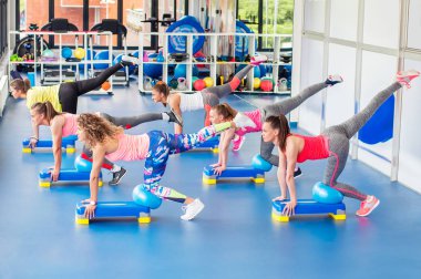 Grup mavi Step çalışma dışarı ve gülümseyen güzel genç kadını.