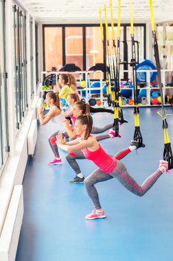 Trx üzerinde çalışma dışarı ve gülümseyen güzel genç kadın grubu.