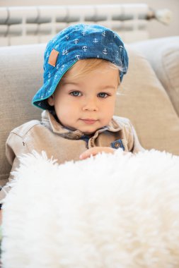 Mavi gözlü güzel giyimli küçük çocuk portresi.