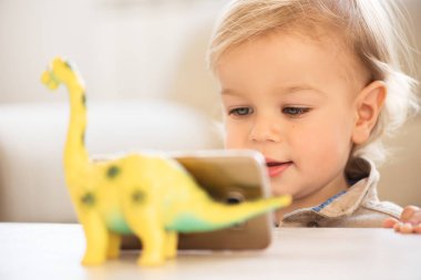 Mavi olan küçük çocuk portresi cep telefonuyla izlerken çizgi film gözleri.