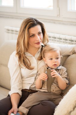 Güzel anne ve küçük oğlu kucağında oturan portresi. Aile değerleri.