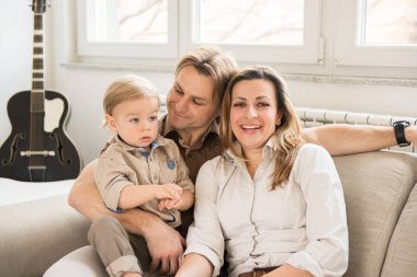 Mutlu anne onların güzel bebek çocuk ile kanepede oturan portresi. Aile değerleri.