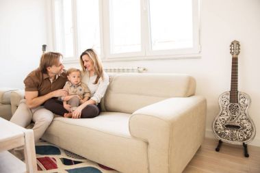 Güzel bebek oğulları ile kanepede oturan mutlu anne. Aile değerleri.