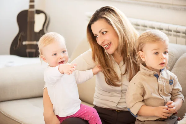 Retrato de la hermosa madre y sus hijos sentados en el regazo. Niña señalando con el dedo. Valores familiares . —  Fotos de Stock