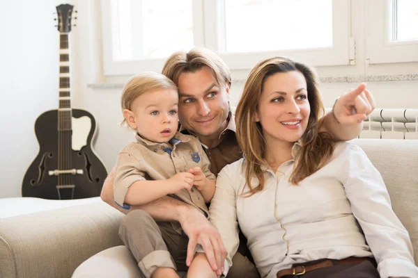 Mutlu anne onların güzel bebek çocuk ile kanepede oturan portresi. Parmak işaret. Aile değerleri.