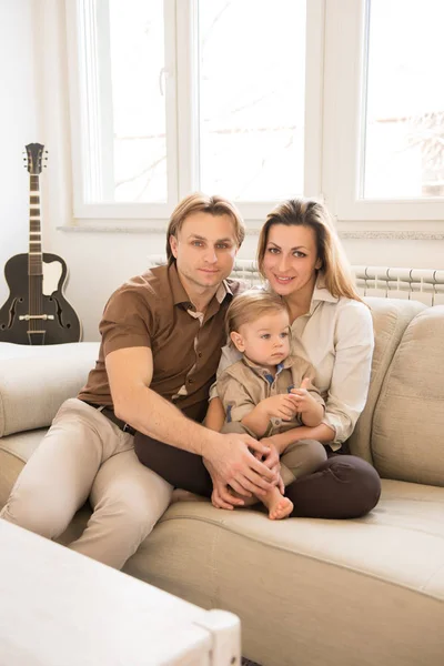 행복 한 부모는 그들의 아름 다운 남자 아기와 함께 소파에 앉아. 가족의 가치. — 스톡 사진