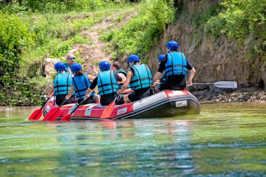 Rafting ekibi güzel güneşli bir günde nehrin aşağısına gider. Arka plan.