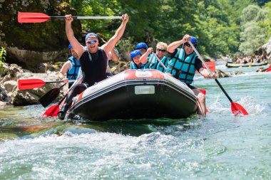 Rafting ekibi güzel güneşli bir günde nehrin aşağısına gider. Cel