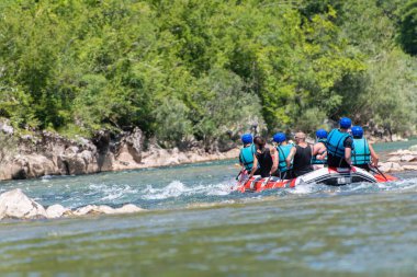 Rafting team goes down the river on the beautiful sunny day. Bac