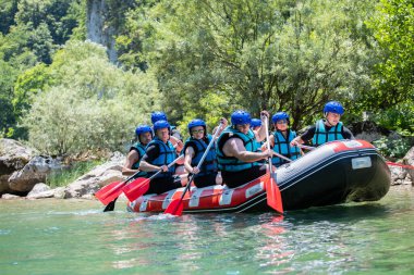 Rafting ekibi güzel güneşli bir günde nehri geçer..
