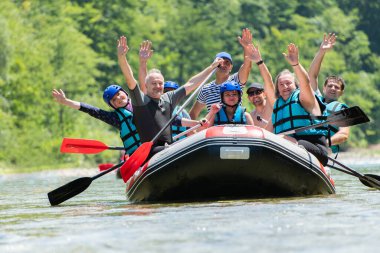 Rafting ekibi güzel güneşli bir günde nehrin aşağısına gider. Cel
