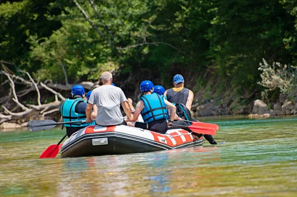 Rafting team goes down the river on the beautiful sunny day. Back view. — 스톡 사진