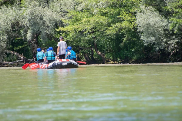 Rafting team goes down the river on the beautiful sunny day. Back view. — 스톡 사진