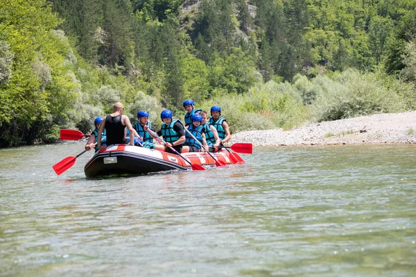 Rafting team goes down the river on the beautiful sunny day.