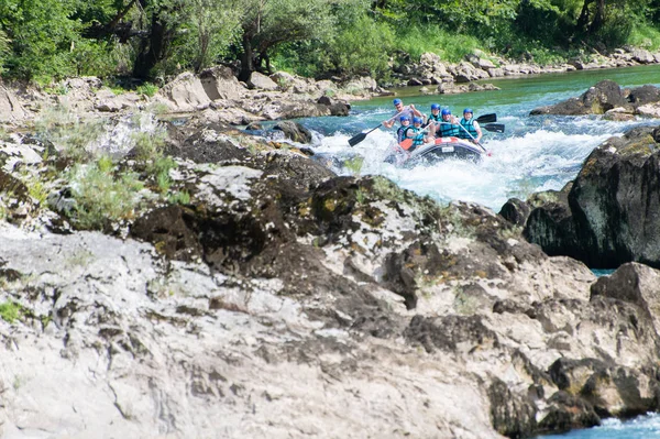 Rafting team goes down the river on the beautiful sunny day.