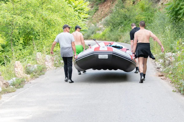 Los balseros satisfechos terminan la ruta llevando el barco en la carretera — Foto de Stock