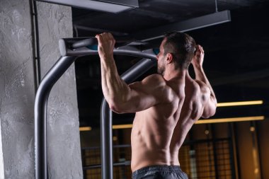 Yatay çizginin arkasında egzersiz yapan kaslı seksi genç adam.