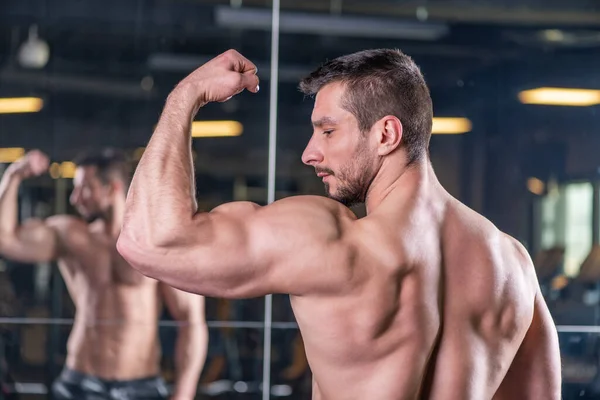 Sexy Jovem Muscular Homem Posando Com Bíceps Contração Frente Espelho — Fotografia de Stock