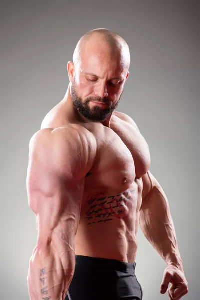 Zbliżenie Sexy Muskularny Kulturysta Pozowanie Szarym Tle Skurcz Tricepsów — Zdjęcie stockowe