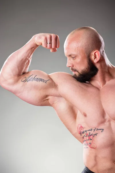 Sexy Muscular Body Buider Pozowanie Szarym Tle Skurcz Bicepsów — Zdjęcie stockowe