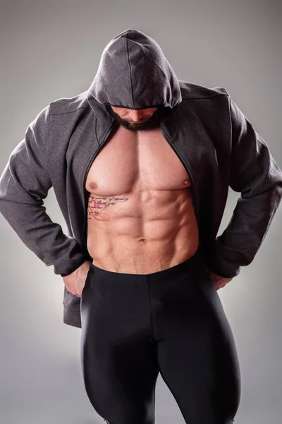 Sexy Bodybuider Muscular Posando Con Sudadera Capucha Sobre Fondo Gris — Foto de Stock