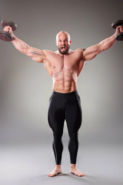 Sexig Muskulös Bodybuider Poserar Med Vikter Grå Bakgrund — Stockfoto