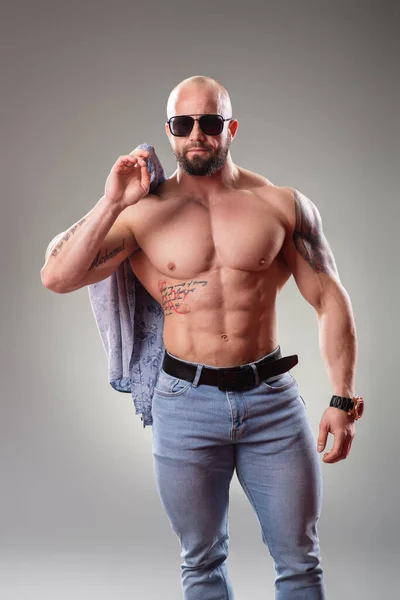 Sexy Muskulöser Bodybuilder Mit Sonnenbrille Auf Grauem Hintergrund Wirft Sein — Stockfoto