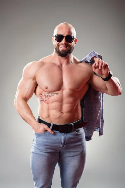Sexy Gespierd Bodybuider Met Zonnebril Grijze Achtergrond Gooien Van Zijn — Stockfoto