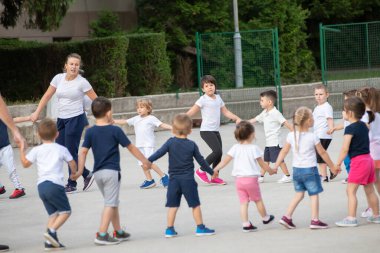 Bir grup çocuk ısınıyor ve dersin ana kısmına hazırlanıyor. Spor okulu