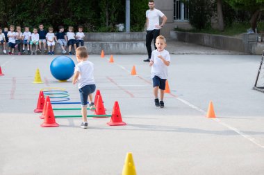 Çokgen üzerinde çalışan bir grup çocuk. Spor okulu