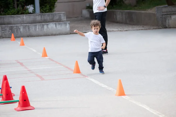 美しい小さな男の子は スポーツ多角形を行う 背景にコーチ — ストック写真