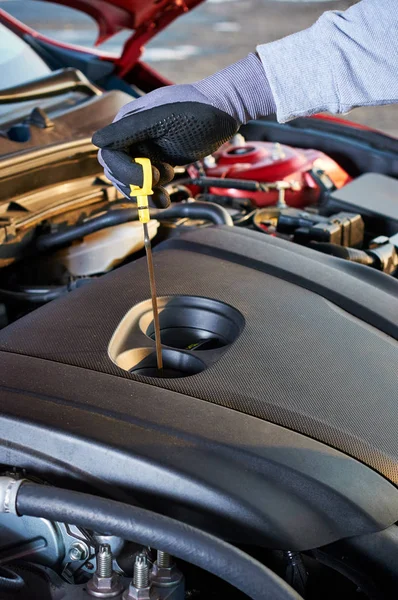 Het controleren van het oliepeil van de motor in de moderne auto. Winter service voor veilig rijden. — Stockfoto