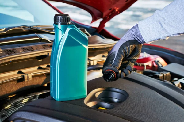 Llenado de aceite de motor en coche moderno. Servicio de invierno para una conducción segura . —  Fotos de Stock