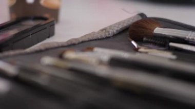 Profesyonel makyaj malzemeleri makyaj çantasında. Çengelli odaklı fırça, tarak, deri çantanın içindeki göz gölgesi.