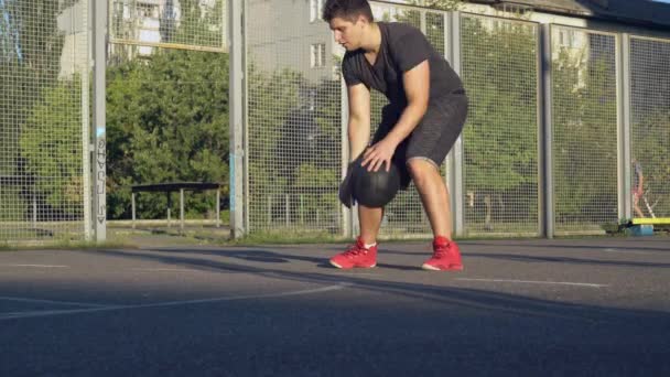 Guapo jugador jugando baloncesto al aire libre — Vídeo de stock