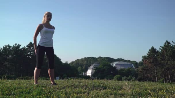 Attractive sportsgirl do everyday workout outdoors. — Stock Video
