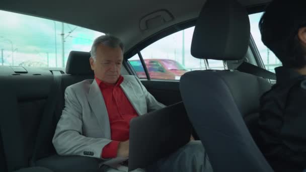 Retrato masculino trabajando en el ordenador en el coche . — Vídeos de Stock