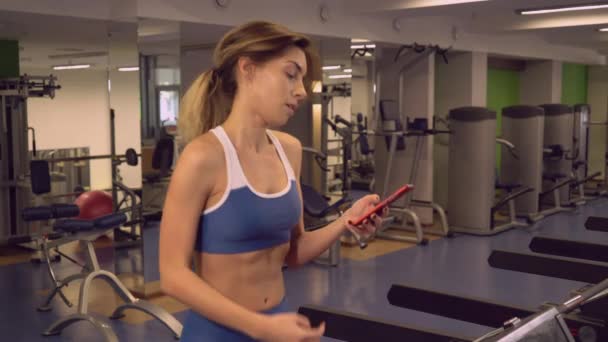 Sportvrouw warming-up lopen texting op mobiele telefoon — Stockvideo
